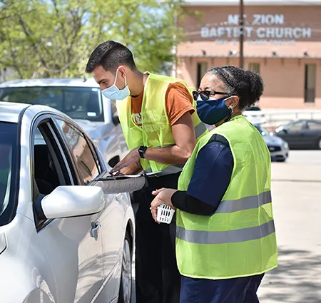 Volunteers at drive-through COVID vaccination clinics