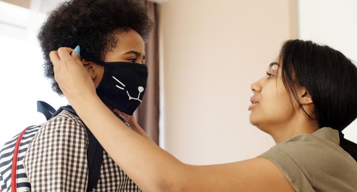 Mother Putting a Face Mask on her Son