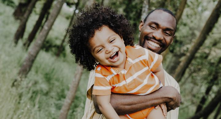 African American father and kid laughting and playing together