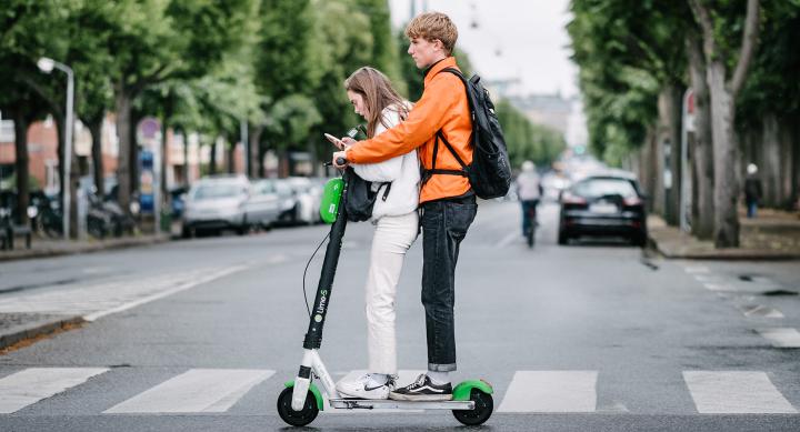 People riding on Electric Scooter. Photo Credit to Kristoffer Trolle from Copenhagen, Denmark, CC BY 2.0, via Wikimedia Commons