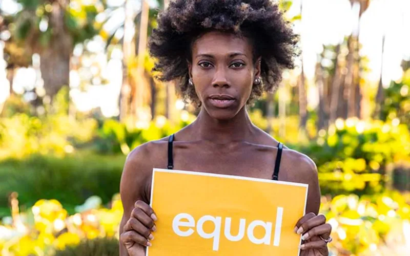 African American woman holding an equal sign.