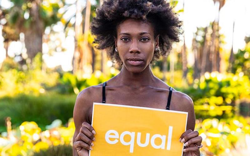 African American woman holding an equal sign.