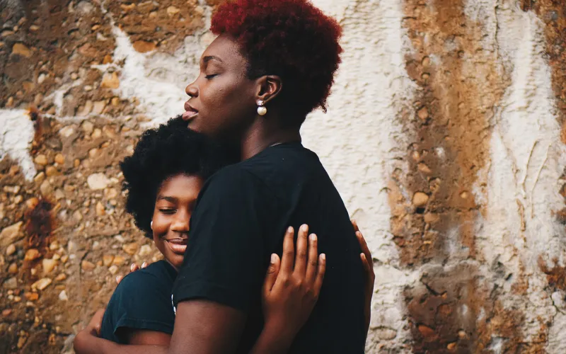 African American mother and kid holding each other