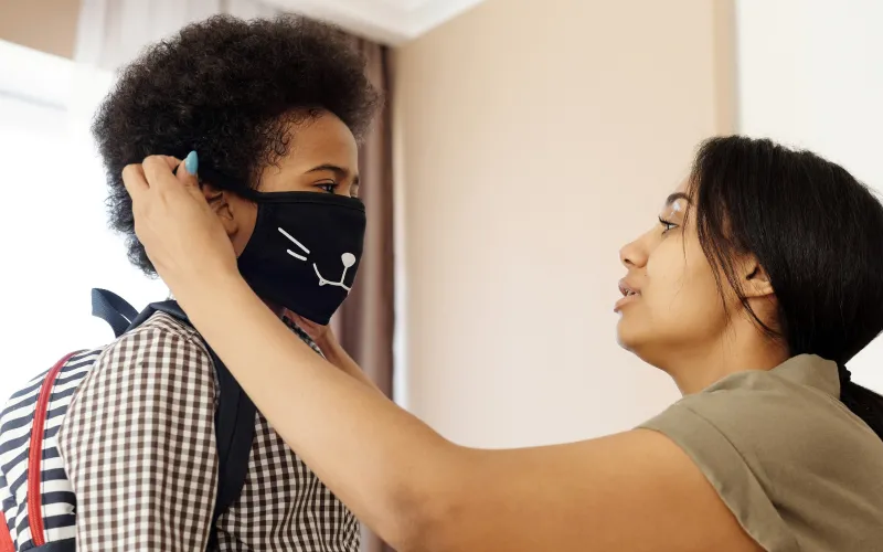 Mother Putting a Face Mask on her Son